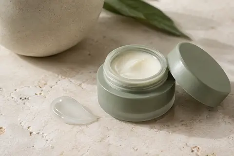 Soin contour des yeux en texture crème-gel présenté sur une pierre claire avec une touche de produit.